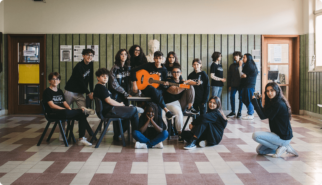 Grupo de adolescentes numa sala, um deles a tocar viola